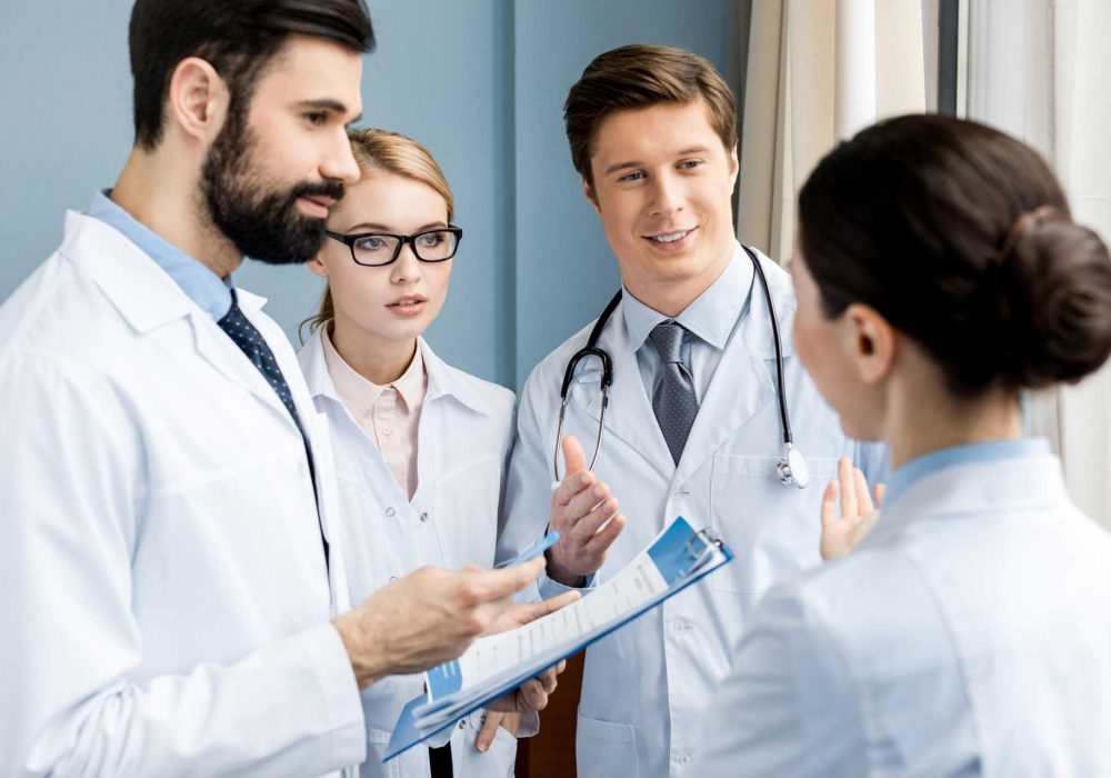 side-view-of-doctors-team-discussing-diagnosis-in-H9FJMNX.jpg